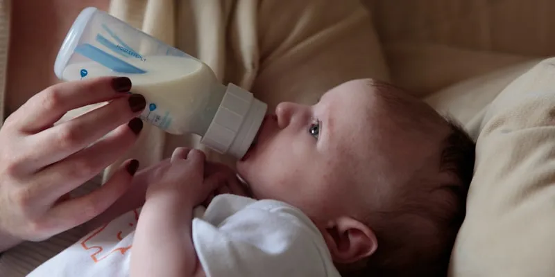 Woman feeding a baby with a bottle